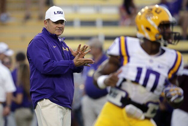 LSU head coach Les Miles claps as quarterback Anthony Jennings (10) warms up before an NCAA college football game in Baton Rouge, La., Saturday, Oct. 18, 2014. (AP Photo/Gerald Herbert)