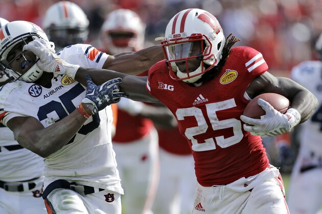 Wisconsin running back Melvin Gordon (25) stiff arms Auburn defensive back Jermaine Whitehead (35) on a 53-yard touchdown run during the third quarter of the Outback Bowl NCAA college football game, Thursday, Jan. 1, 2015, in Tampa, Fla. (AP Photo/Chris O'Meara)