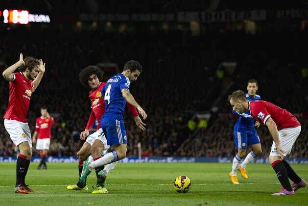 Chelsea's Cesc Fabregas, 4th left, fights for the ball against Manchester United players including Marouane Fellaini, third left, during the English Premier League soccer match between Manchester United and Chelsea at Old Trafford Stadium, Manchester, England, Sunday Oct. 26, 2014. (AP Photo/Jon Super)
