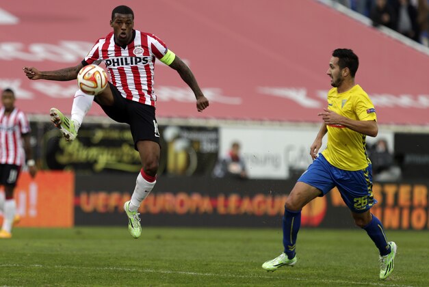 PSV's Georginio Wijnaldum, left, vies for the ball with Estoril's Ruben Fernandes during an Europa League group E soccer match between PSV Eindhoven and Estoril at the Antonio Coimbra da Mota stadium in Estoril, Portugal, Friday, Nov. 28, 2014. The match that resumed Friday after being suspended on Thursday due to the heavy rain ended in a 3-3 draw. (AP Photo/Francisco Seco)
