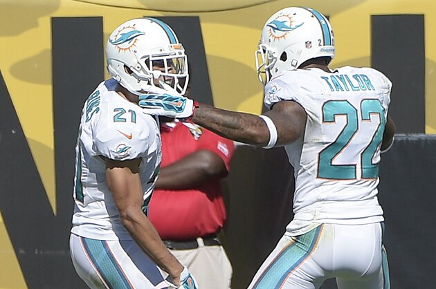 Miami Dolphins cornerback Brent Grimes (21) and cornerback Jamar Taylor (22) celebrate after Grimes intercepted a pass and returned it for 22-yards and a touchdown during the first half of an NFL football game in Jacksonville, Fla., Sunday, Oct. 26, 2014. (AP Photo/Phelan M. Ebenhack)