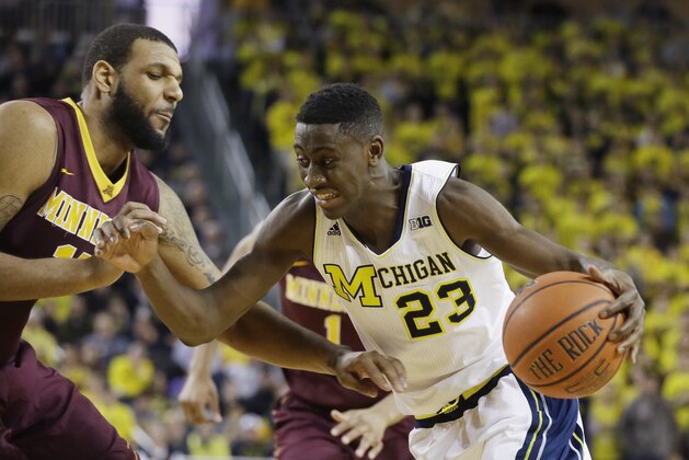 Michigan guard Caris LeVert (23) drives on Minnesota forward Maurice Walker during the second half of an NCAA basketball game, Saturday, Jan. 10, 2015, in Ann Arbor, Mich. Michigan defeated Minnesota 62-57. (AP Photo/Carlos Osorio)