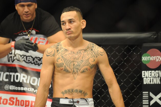 Aug 23, 2014; Tulsa, OK, USA; Max Holloway (red gloves) fights Clay Collard (blue gloves) in a Featherweight Bout, Holloway enters ring at BOK Center. Mandatory Credit: Mark D. Smith-USA TODAY Sports
