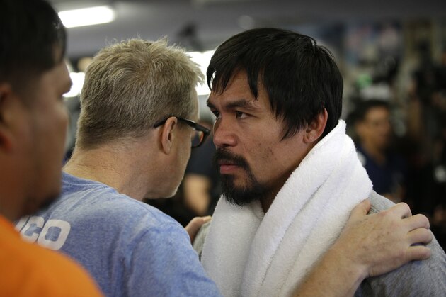 Boxer Manny Pacquiao, right, of the Philippines, listens to his trainer Freddie Roach during a media workout at Wild Card Boxing Club, Wednesday, April 15, 2015, in Los Angeles. Pacquiao is scheduled to fight Floyd Mayweather Jr. in a welterweight boxing match in Las Vegas on May 2. (AP Photo/Jae C. Hong)