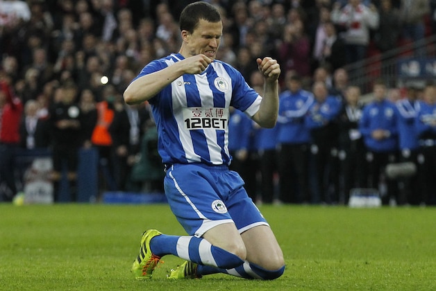 Wigan Athletic's Gary Caldwell drops to his knee after his miss in a penalty shoot-out against Arsenal during their English FA Cup semifinal soccer match at Wembley Stadium in London, Saturday, April 12, 2014. (AP Photo/Sang Tan)