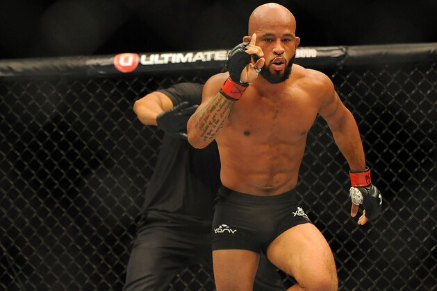 Sep 27, 2014; Las Vegas, NV, USA; Demetrious Johnson (red gloves) celebrates after referee Herb Brooks stops a featherweight title bout against Chris Cariaso (blue gloves) during UFC 178 at MGM Grand Garden Arena. Mandatory Credit: Stephen R. Sylvanie-USA TODAY Sports