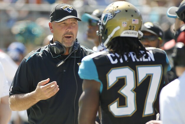 Jacksonville Jaguars head coach Gus Bradley, left, talks with strong safety Johnathan Cyprien (37) on the sidelines during the first half of an NFL football game against the Cleveland Browns in Jacksonville, Fla., Sunday, Oct. 19, 2014. (AP Photo/Stephen B. Morton)