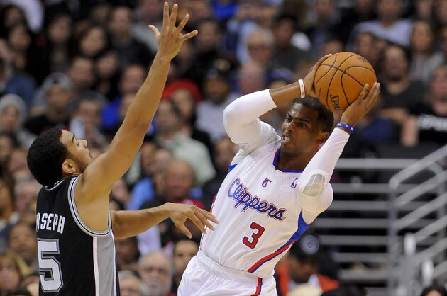 Los Angeles Clippers guard Chris Paul (3) looks around San Antonio Spurs guard Cory Joseph (5) for the open man in the first half of a NBA basketball game, Tuesday, Feb. 18, 2014, in Los Angeles.(AP Photo/Gus Ruelas)