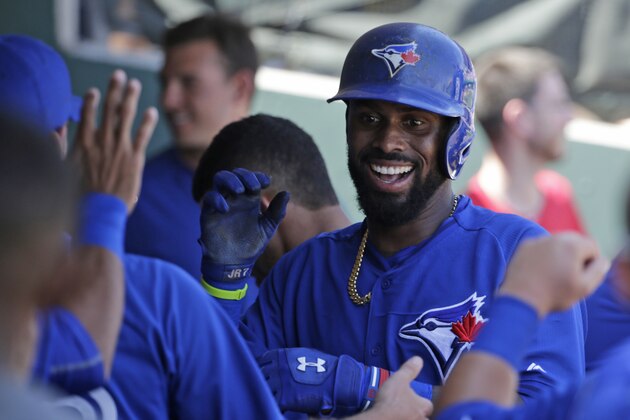 Toronto Blue Jays shortstop Jose Reyes (7) greets teammates in the dugout after hitting a first-inning, lead-off, solo home run off Philadelphia Phillies starting pitcher Cole Hamels in a spring training baseball game in Clearwater, Fla., Saturday, March 21, 2015. (AP Photo/Kathy Willens)