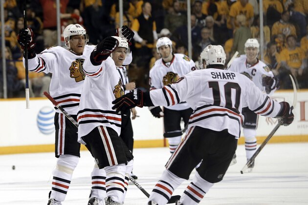 Chicago Blackhawks defenseman Duncan Keith, second from left, celebrates with Patrick Sharp (10) after Keith scored the game-winning goal against the Nashville Predators in the second overtime of Game 1 of an NHL Western Conference hockey playoff series Wednesday, April 15, 2015, in Nashville, Tenn. The Blackhawks won 4-3. (AP Photo/Mark Humphrey)