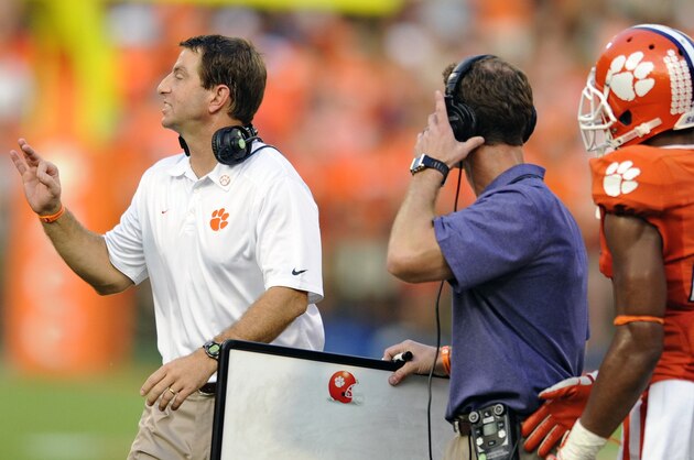 Clemson head coach Dabo Swinney, left, calls out a play to his team while defensive coordinator Brent Venables, center, and Garry Peters watch during the second half of an NCAA college football game against Boston College, Saturday, Oct. 12, 2013, at Memorial Stadium in Clemson, S.C. Clemson won 24-14. (AP Photo/ Richard Shiro)