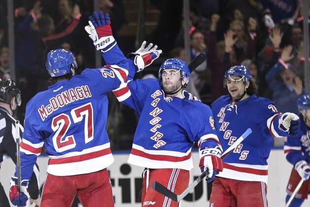 New York Rangers' Ryan McDonagh, left, celebrates with teammate Keith Yandle, center, and Mats Zuccarello, right, during the first period of Game 1 in the first round of the NHL hockey Stanley Cup playoffs Thursday, April 16, 2015, in New York.  (AP Photo/Frank Franklin II)