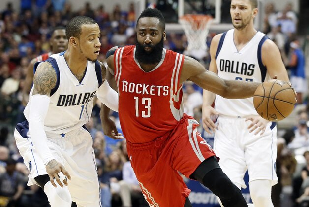 Dallas Mavericks' Monta Ellis (11) defends as Houston Rockets' James Harden (13) drives to the basket for a score in the first half of an NBA basketball game Thursday, April 2, 2015, in Dallas. The Mavericks' Chandler Parsons watches the play from the rear. (AP Photo/Tony Gutierrez)