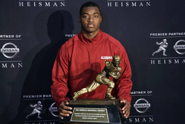 Alabama receiver Amari Cooper, a Heisman Trophy finalist, poses with the trophy at a press conference, Friday, Dec. 12, 2014, in New York. The award is to be presented Saturday. (AP Photo/Richard Drew)