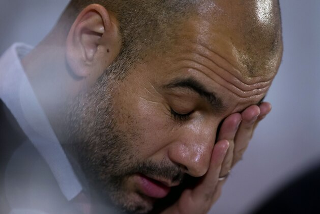 Bayern's head coach Pep Guardiola wipes his face during a press conference in Manchester, England, Monday, Nov. 24, 2014. Bayern Munich will play Manchester City on Tuesday in a Champions League Group E soccer match. (AP Photo/Jon Super)