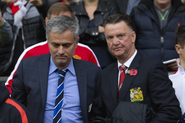Chelsea's manager Jose Mourinho, center left, makes his way from the opposition dugout after greeting Manchester United manager Louis van Gaal, centre right, during their English Premier League soccer match between Manchester United and Chelsea at Old Trafford Stadium, Manchester, England, Sunday Oct. 26, 2014. (AP Photo/Jon Super)