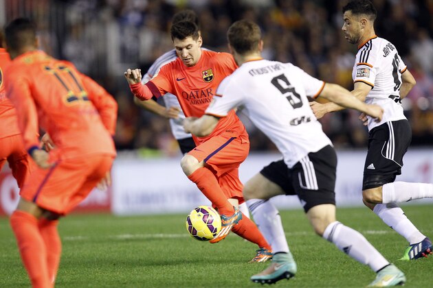 Barcelona's Lionel Messi, from Argentina, drives the ball past Valencia's Mustafi  during a Spanish La Liga soccer match at the Mestalla stadium in Valencia, Spain, on Sunday, Nov. 30, 2014.(AP Photo/Alberto Saiz)