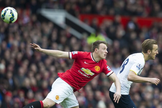 Manchester United's Phil Jones, centre, fights for the ball against Tottenham Hotspur's Harry Kane during the English Premier League soccer match between Manchester United and Tottenham Hotspur at Old Trafford Stadium, Manchester, England, Sunday March 15, 2015. (AP Photo/Jon Super)