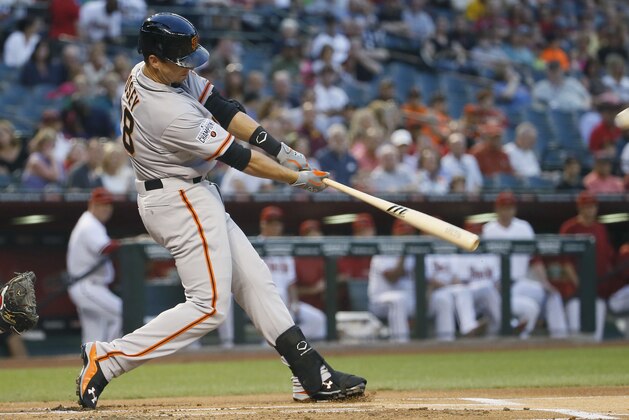 San Francisco Giants' Buster Posey follows through on a two run home run during the first inning of a MLB baseball game against the Arizona Diamondbacks, Tuesday, April 7, 2015, in Phoenix. (AP Photo/Matt York)
