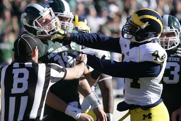 Michigan's Delano Hill, right, shoves Michigan State quarterback Connor Cook during the first quarter of an NCAA college football game, Saturday, Oct. 25, 2014, in East Lansing, Mich. Hill was penalized on the play. (AP Photo/Al Goldis)