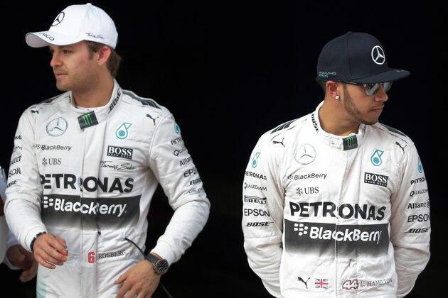 Mercedes driver Lewis Hamilton, right, of Britain stands next to teammate Nico Rosberg of Germany after taking pole in the qualifying session for the Chinese Formula One Grand Prix at Shanghai International Circuit in Shanghai, China, Saturday, April 11, 2015. Rosberg finished second for Sunday's race. (AP Photo/Andy Wong)
