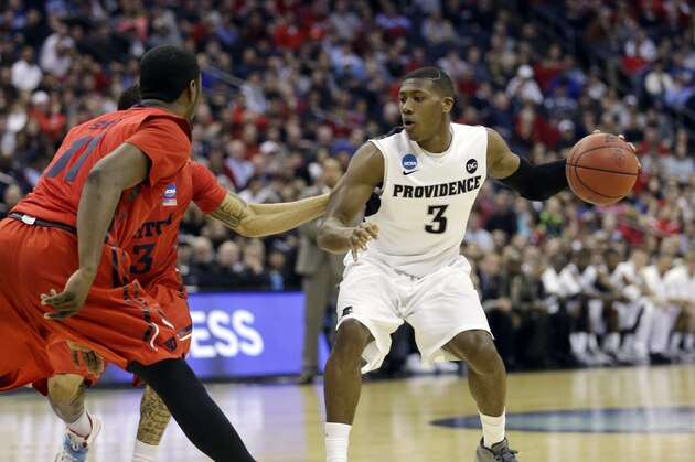 Providence's Kris Dunn (3) goes against Dayton's Scoochie Smith (11) and Kyle Davis in the first half of an NCAA tournament college basketball game in the Round of 64 in Columbus, Ohio Friday, March 20, 2015. (AP Photo/Tony Dejak)