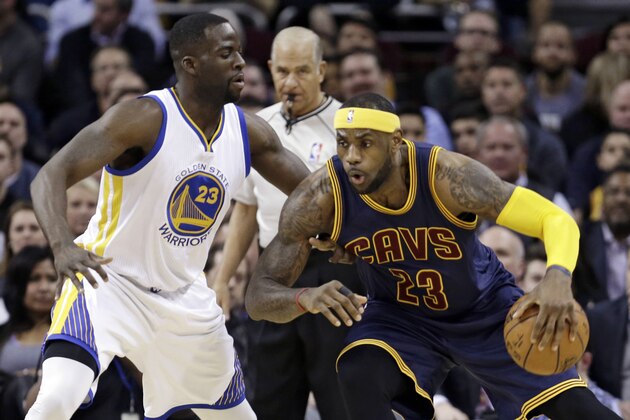 Cleveland Cavaliers' LeBron James, right, drives past Golden State Warriors’ Draymond Green during the first quarter of an NBA basketball game Thursday, Feb. 26, 2015, in Cleveland. (AP Photo/Tony Dejak)