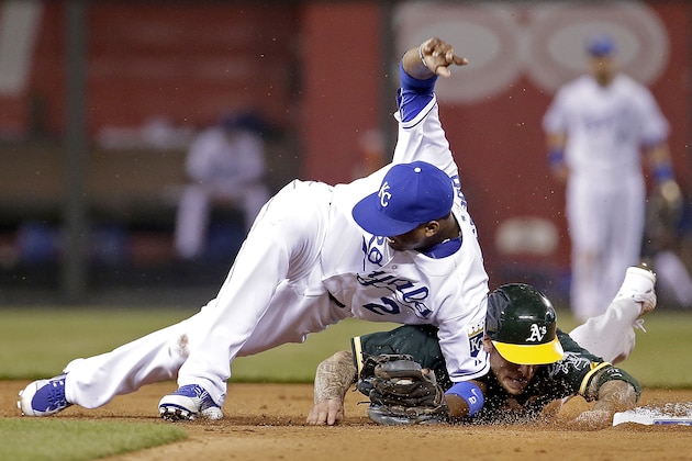 Kansas City Royals shortstop Alcides Escobar (2) and Oakland Athletics' Brett Lawrie become entangled after Lawrie was forced out during the seventh inning of a baseball game Friday, April 17, 2015, in Kansas City, Mo. (AP Photo/Charlie Riedel)