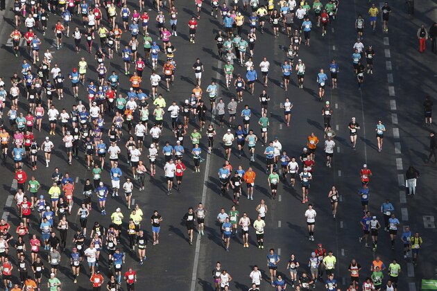 Runners make their way down the Champs Elysees avenue at the start of the 39th Paris Marathon in Paris, Sunday, April 12, 2015. (AP Photo/Thibault Camus)