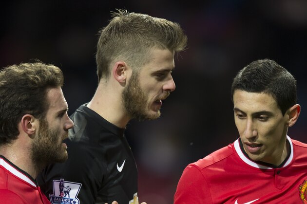 Manchester United's Angel Di Maria, right, congratulates teammates Juan Mata, left, and goalkeeper David De Gea after their 3-1 win during the English Premier League soccer match between Manchester United and Leicester at Old Trafford Stadium, Manchester, England, Saturday Jan. 31, 2015. (AP Photo/Jon Super)