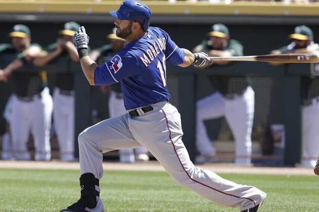 Texas Rangers' Mitch Moreland swings for a single against the Oakland Athletics in the second inning of a spring training exhibition baseball game Friday, March 27, 2015, in Mesa, Ariz. (AP Photo/Ben Margot)