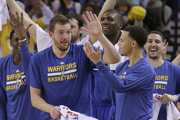 Golden State Warriors' David Lee, front left, and Stephen Curry celebrate a score by the team, during the first half of an NBA basketball game against the Phoenix Suns on Thursday, April 2, 2015, in Oakland, Calif. (AP Photo/Ben Margot)