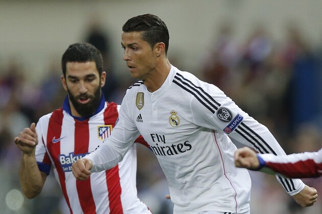 Atletico's Arda Turan, left, challenges Real Madrid's Cristiano Ronaldo, right, during the Champions League quarterfinal, first leg soccer match between Atletico de Madrid and Real Madrid at the Vicente Calderon stadium in Madrid, Spain, Tuesday, April 14, 2015. (AP Photo/Daniel Ochoa de Olza)