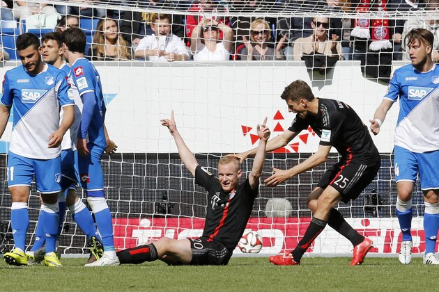 Bayern's Sebastian Rode, center left, celebrates his side's opening goal with team mate Thomas Mueller during a German first division Bundesliga soccer match between TSG 1899 Hoffenheim and Bayern Munich in Sinsheim, Germany, Saturday, April 18, 2015. (AP Photo/Michael Probst)