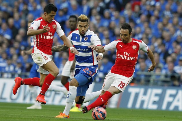 Reading’s Daniel Williams, centre, watches Arsenal's Alexis Sanchez, left, and Arsenal's Santi Cazorla tangle as they defend the ball during the English FA Cup semifinal soccer match between Arsenal and Reading at Wembley stadium in London, Saturday, April 18, 2015. (AP Photo/Alastair Grant)