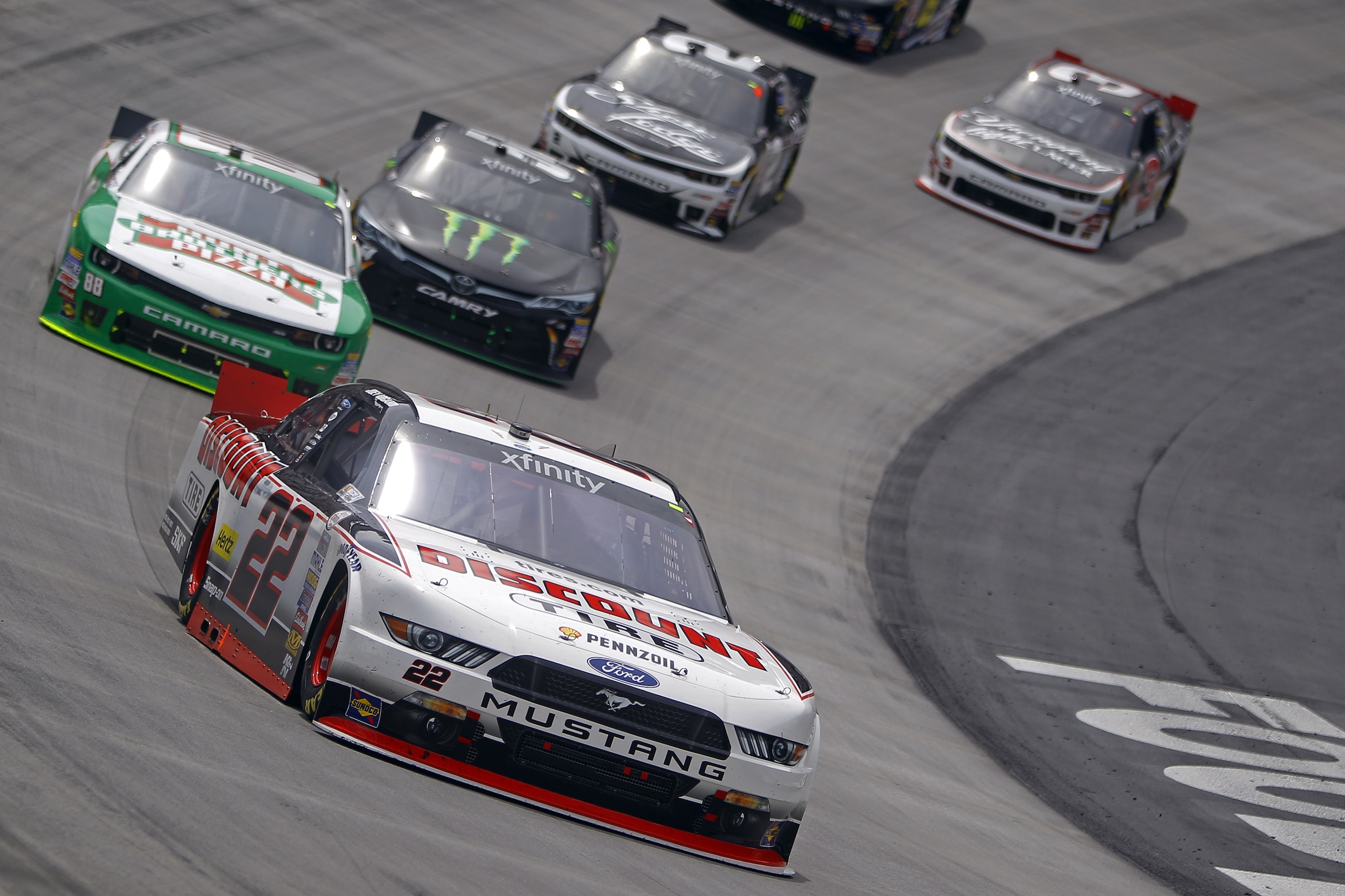 Driver Joey Logano (22) leads Kevin Harvick (88), Denny Hamlin (54), Brian Scott (2), and Ty Dillon (3) during the NASCAR Xfinity Series auto race at Bristol Motor Speedway on Saturday, April 18, 2015, in Bristol, Tenn. (AP Photo/Wade Payne)
