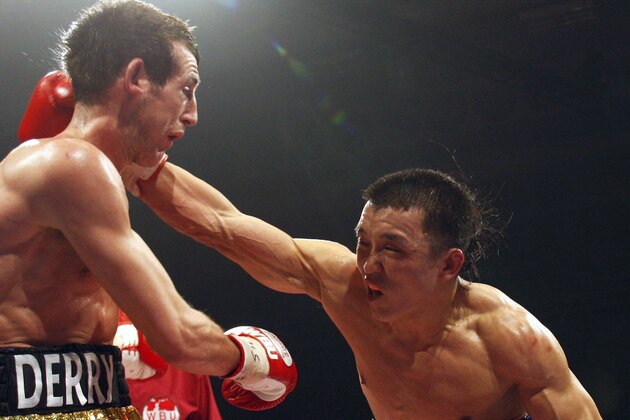 Boxer Choi Tseveenpurev of Mongolia, right, throws a punch at Britain's Derry Mathews, left, during their World Boxing Union Featherweight Championship fight in Bolton, England, Saturday, April 5, 2008. (AP Photo/Jon Super)
