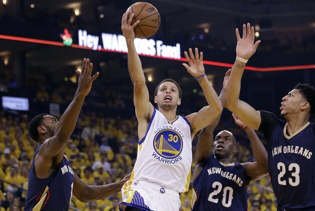 Golden State Warriors' Stephen Curry (30) shoots past New Orleans Pelicans' Tyreke Evans, left, Quincy Pondexter (20) and Anthony Davis (23) during the first half in Game 1 of the NBA basketball playoffs Saturday, April 18, 2015, in Oakland, Calif. (AP Photo/Marcio Jose Sanchez)