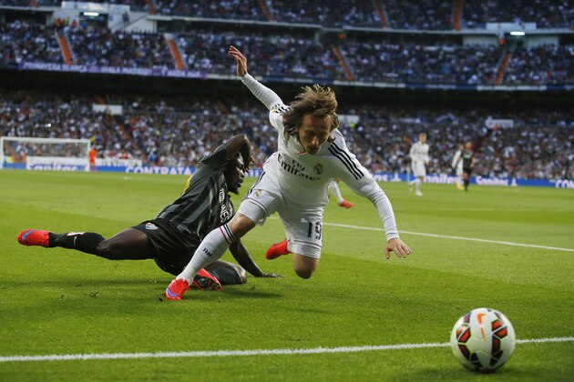 Real Madrid's Luka Modric, right, in action with Malaga's Boka, left, during a Spanish La Liga soccer match between Real Madrid and Malaga at the Santiago Bernabeu stadium in Madrid, Spain, Saturday, April 18, 2015. (AP Photo/Andres Kudacki)
