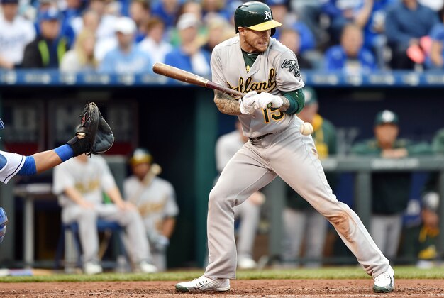 Apr 18, 2015; Kansas City, MO, USA; Oakland Athletics third basemen Brett Lawrie (15) gets hit with a pitch from Kansas City Royals pitcher Yordano Ventura (not pictured) during the fourth inning at Kauffman Stadium. Mandatory Credit: Peter G. Aiken-USA TODAY Sports
