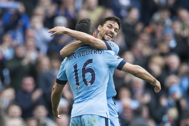 Manchester City's Sergio Aguero, left, celebrates with teammate Jesus Navas after scoring against West Ham United's during the English Premier League soccer match between Manchester City and West Ham United at the Etihad Stadium, Manchester, England, Sunday April 19, 2015. (AP Photo/Jon Super)
