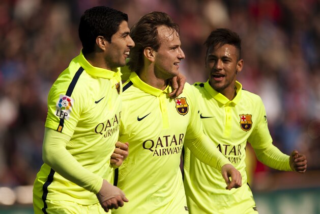 Barcelona's Ivan Rakitic, center, celebrates his goal with teammates Luis Suarez, left, and Neymar during a Spanish La Liga soccer match between Granada and FC Barcelona at Los Carmenes stadium in Granada, Spain, Saturday Feb. 28, 2015. (AP Photo/Daniel Tejedor)