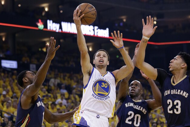 Golden State Warriors' Stephen Curry (30) shoots past New Orleans Pelicans' Tyreke Evans, left, Quincy Pondexter (20) and Anthony Davis (23) during the first half in Game 1 of the NBA basketball playoffs Saturday, April 18, 2015, in Oakland, Calif. (AP Photo/Marcio Jose Sanchez)