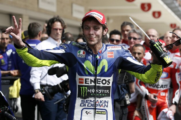 Valentino Rossi of Italy celebrates on the paddock after finishing third in the Texas MotoGP race at the Circuit of the Americas Sunday, April 12, 2015, in Austin, Texas. Rossi finished behind race winner Marc Marquez and second place finisher Andrea Dovizioso. (AP Photo/Tony Gutierrez)