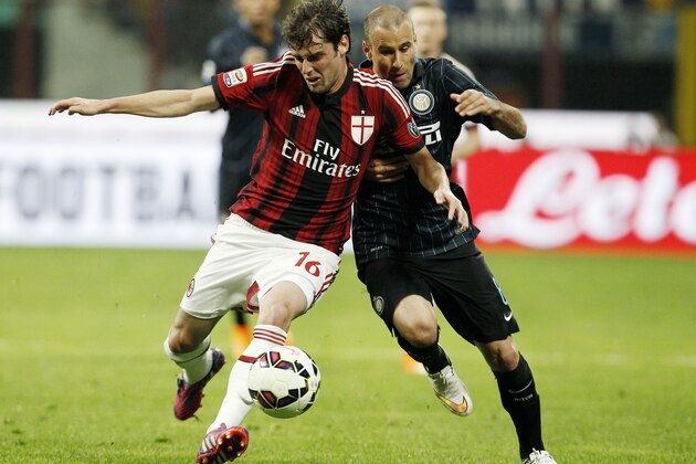 AC Milan's Andrea Poli, left, challenges for the ball with Inter Milan's Rodrigo Palacio during the Serie A soccer match between Inter Milan and AC Milan at the San Siro stadium in Milan, Italy, Sunday, April 19, 2015. (AP Photo/Antonio Calanni)