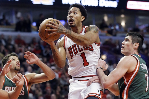 Chicago Bulls guard Derrick Rose, center, drives to the basket against Milwaukee Bucks forward Ersan Ilyasova, right, and guard Michael Carter-Williams during the second half in Game 1 of the NBA basketball playoffs Saturday, April 18, 2015, in Chicago. (AP Photo/Nam Y. Huh)