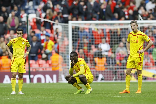 Liverpool's Philippe Coutinho, left Mario Balotelli and Jordan Hendersonon the pitch after the end of the English FA Cup semifinal soccer match between Liverpool and  Aston Villa at Wembley Stadium in London, Sunday, April 19, 2015.  Aston Villa won the match 2-1 and will play Arsenal in the final.(AP Photo/Kirsty Wigglesworth)