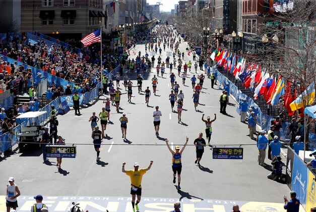 Apr 21, 2014; Boston, MA, USA; Runners stream down Boylston Street at the exact minute one year ago the first bomb exploded near the finish line during the 2014 Boston Marathon. Mandatory Credit: Greg M. Cooper-USA TODAY Sports