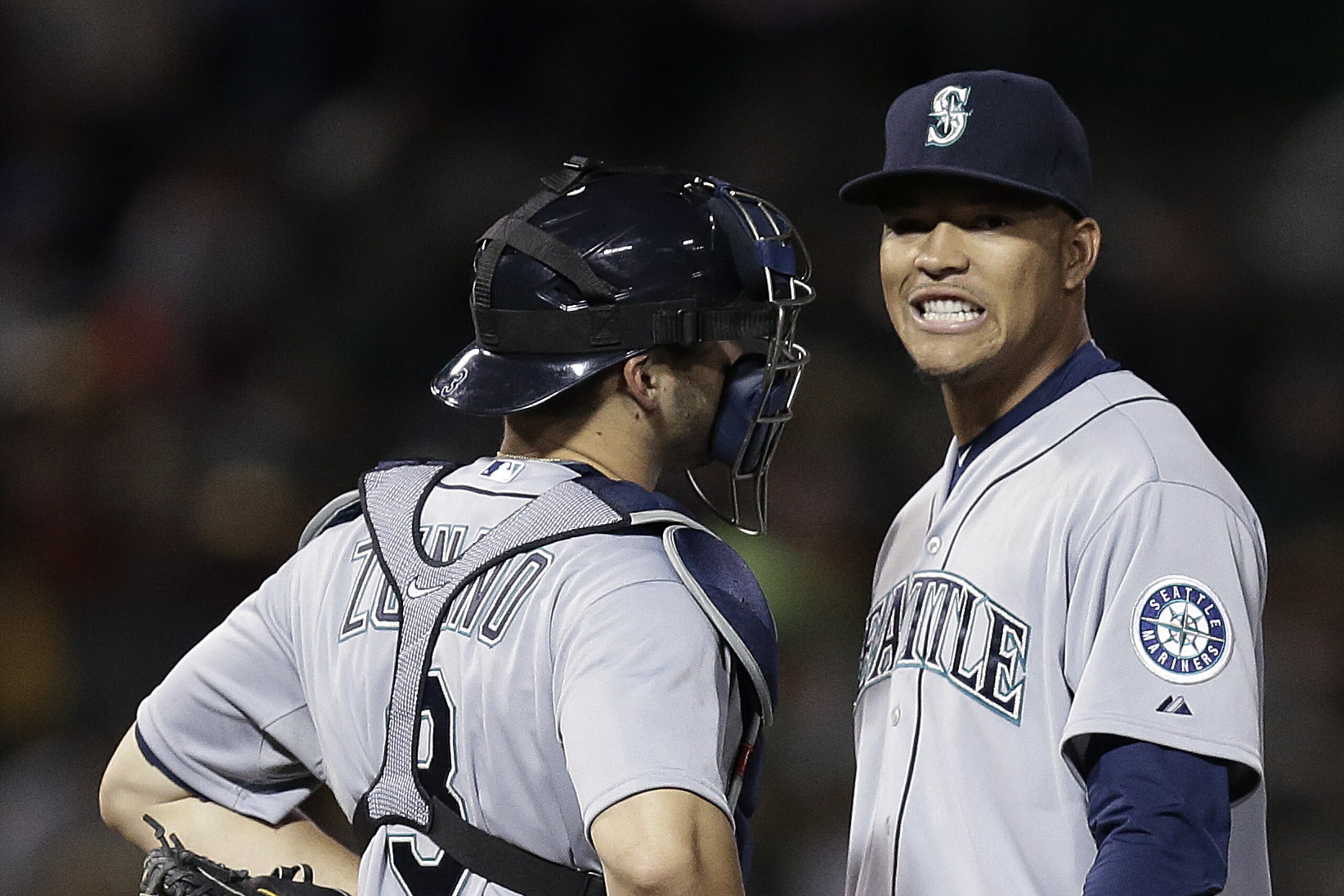 Seattle Mariners' Taijuan Walker, right, speaks with catcher Mike Zunino in the fourth inning of a baseball game against the Oakland Athletics on Friday, April 10, 2015, in Oakland, Calif. (AP Photo/Ben Margot)