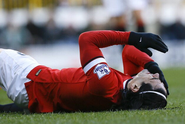 Manchester United's Radamel Falcao holds his face after a challenge with Tottenham's Jan Vertonghen during the English Premier League soccer match between Tottenham Hotspur and Manchester United at White Hart Lane Stadium in London, Sunday, Dec. 28, 2014. (AP Photo/Kirsty Wigglesworth)